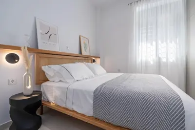a bedroom with a large bed and a window at 'Green & Blue' Castella Luxury Suites in Piraeus