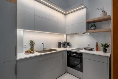 a kitchen with white cabinets and a sink at 'Green & Blue' Castella Luxury Suites in Piraeus