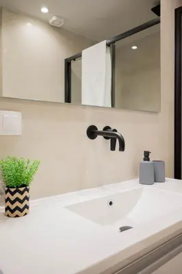 a bathroom sink with a black faucet and a mirror at Sweet Family Home 1 in Athens