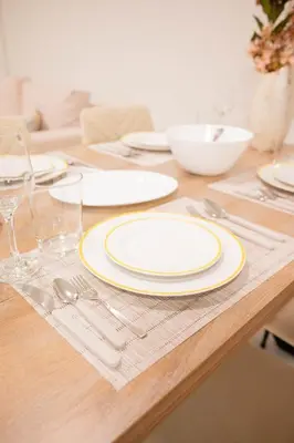 a wooden table with white plates and silverware on it at Sweet Family Home 1 in Athens