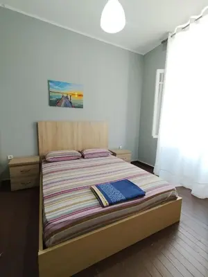 a bedroom with a bed with a striped comforter at Apartment Atiki metro shared bathroom and kitchen in Athens