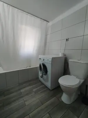 a bathroom with a toilet and a washing machine at Apartment Atiki metro shared bathroom and kitchen in Athens