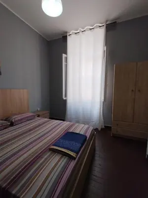 a bedroom with a large bed and a window at Apartment Atiki metro shared bathroom and kitchen in Athens