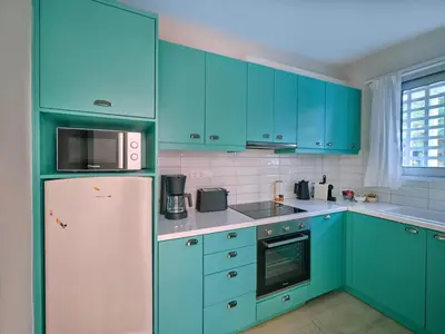 a kitchen with blue cabinets and a refrigerator at 12LVE Vouliagmeni Apartment in Athens