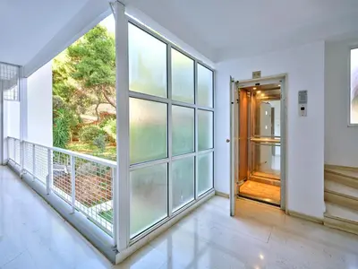 an empty room with a large window and a door at 12LVE Vouliagmeni Apartment in Athens
