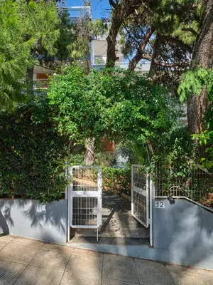 a white gate in front of a tree at 12LVE Vouliagmeni Apartment in Athens