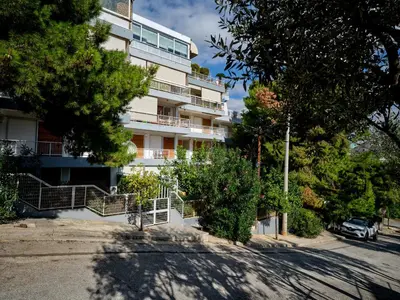a white building with trees in front of it at 12LVE Vouliagmeni Apartment in Athens