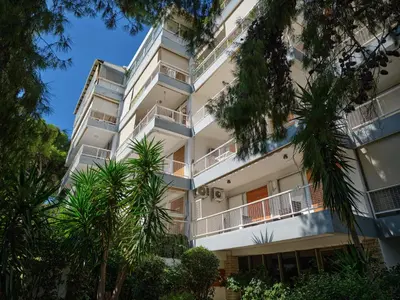an apartment building with palm trees in front of it at 12LVE Vouliagmeni Apartment in Athens