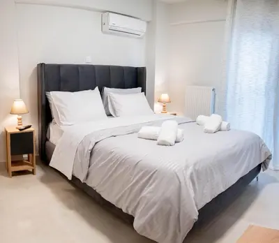 a bedroom with a large bed with white sheets and pillows at Sweet Family Home 3 in Athens