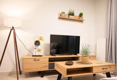 a living room with a tv on a wooden table at Sweet Family Home 3 in Athens