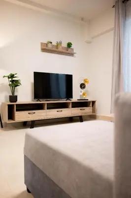 a living room with a flat screen tv on a entertainment center at Sweet Family Home 3 in Athens