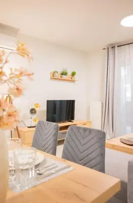 a dining room with a table and chairs and a television at Sweet Family Home 2 in Athens