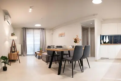 a dining room and living room with a table and chairs at Sweet Family Home 2 in Athens
