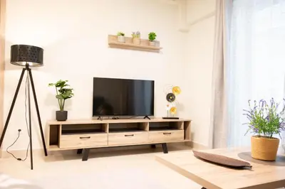 a living room with a television on a wooden entertainment center at Sweet Family Home 2 in Athens