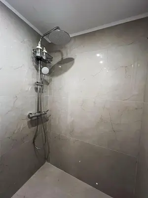 a shower in a bathroom with a stone wall at Filopappou Nest in Athens