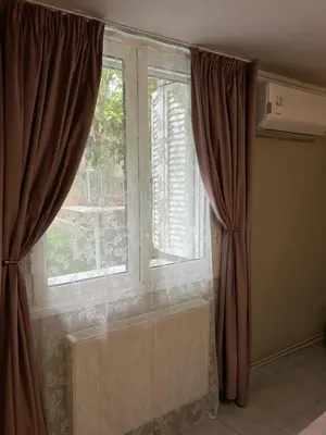 a window with brown curtains in a room at Filopappou Nest in Athens