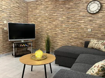 a living room with a couch and a clock on a brick wall at Filopappou Nest in Athens