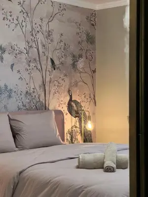 a bedroom with a bed with a bird on the wall at Filopappou Nest in Athens