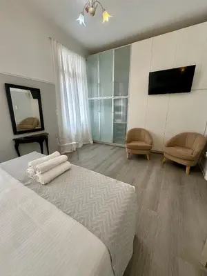 a bedroom with a bed and two chairs and a television at elan RESIDENCE in Athens