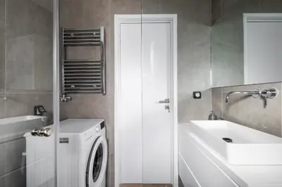 a bathroom with a washing machine and a sink at Modern Two-Bedroom Haven near Paleo Faliro Beach in Athens
