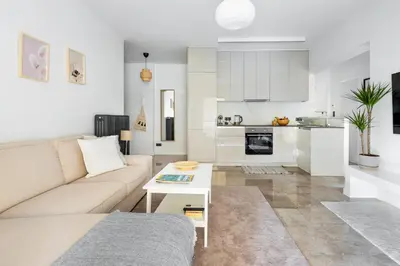 a white living room with a couch and a table at Modern Two-Bedroom Haven near Paleo Faliro Beach in Athens