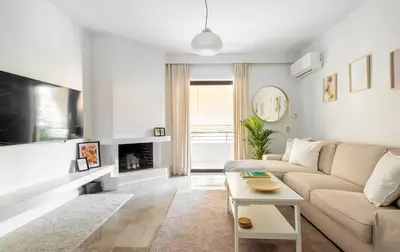 a living room with a couch and a table at Modern Two-Bedroom Haven near Paleo Faliro Beach in Athens