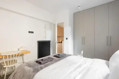 a bedroom with a bed and a desk and a chair at Modern Two-Bedroom Haven near Paleo Faliro Beach in Athens