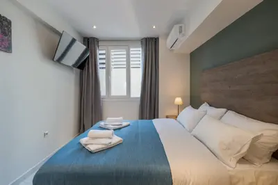 a bedroom with a large bed with two towels on it at Ermou Boutique Studios in Monastiraki in Athens