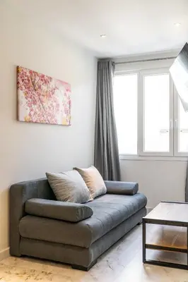 a living room with a couch in front of a window at Ermou Boutique Studios in Monastiraki in Athens