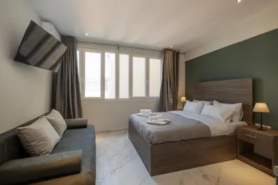 a bedroom with a bed and a couch at Ermou Boutique Studios in Monastiraki in Athens
