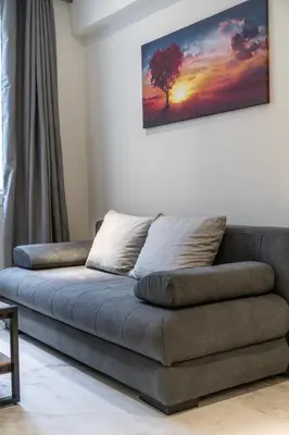 a couch in a living room with a tree on the wall at Ermou Boutique Studios in Monastiraki in Athens