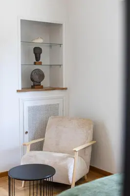 a living room with a chair and a table at Unbeatable Acropolis Elegant 2-Bedroom Apartment on Areopagitou in Athens