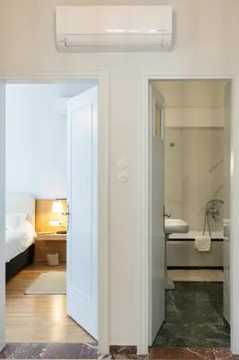 a bathroom with a white door leading to a bedroom at Unbeatable Acropolis Elegant 2-Bedroom Apartment on Areopagitou in Athens