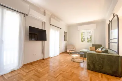 a living room with a couch and a flat screen tv at Unbeatable Acropolis Elegant 2-Bedroom Apartment on Areopagitou in Athens