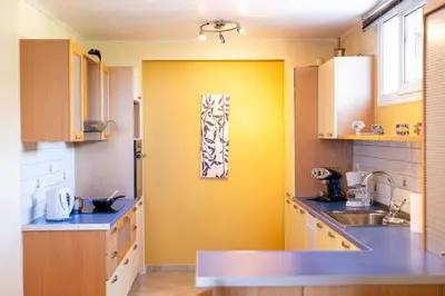 a kitchen with yellow walls and blue counter tops at Artemis Riviera Near Athen's Airport By SEM in Artemida