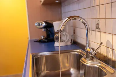 a kitchen sink with water coming from a faucet at Artemis Riviera Near Athen's Airport By SEM in Artemida
