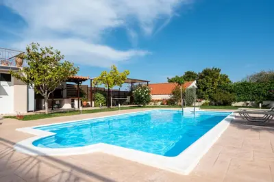 a swimming pool in a yard with a house at Artemis Riviera Near Athen's Airport By SEM in Artemida