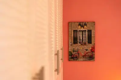 a red wall with a mirror and a bike on it at Artemis Riviera Near Athen's Airport By SEM in Artemida