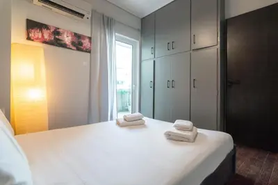a bedroom with a bed with two towels on it at Athens Charm Meets Contemporary Design in Thissio in Athens