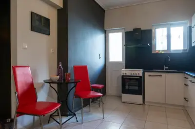 a kitchen with red chairs and a table in it at Athens Charm Meets Contemporary Design in Thissio in Athens