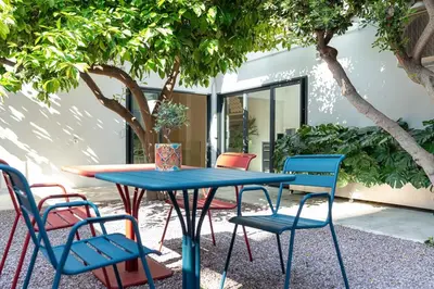 a blue table and chairs in a courtyard with trees at Athens Design Residence in Athens