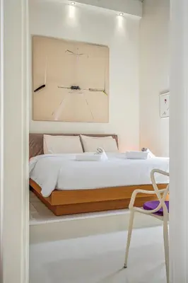 a bedroom with a large bed and a chair at Athens Design Residence in Athens