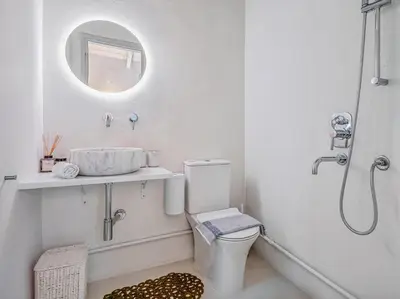 a white bathroom with a toilet and a mirror at Athens Design Residence in Athens