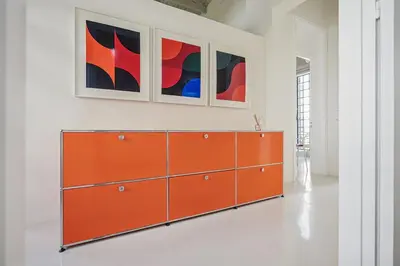 an orange dresser in a white room with two paintings at Athens Design Residence in Athens