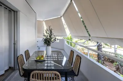 a balcony with a table and chairs and a window at Stylish 1BR Retreat Near Alimos Beach Tram in Athens