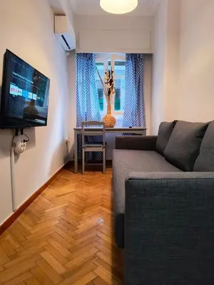 a living room with a couch and a flat screen tv at TCG Central Apartment in Athens