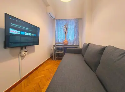 a living room with a couch and a flat screen tv at TCG Central Apartment in Athens