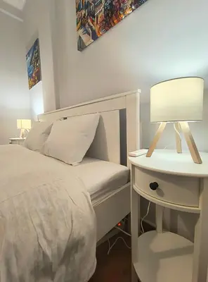 a bedroom with a bed and a table with a lamp at TCG Central Apartment in Athens
