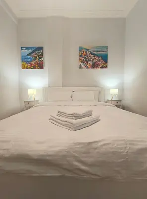 a white bed with towels on top of it at TCG Central Apartment in Athens
