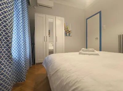 a bedroom with a bed and a blue shower curtain at TCG Central Apartment in Athens